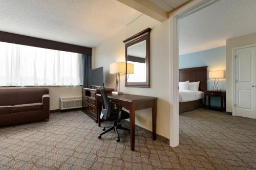 a hotel room with a desk and a bed and a mirror at Holiday Inn Birmingham-Airport by IHG in Birmingham