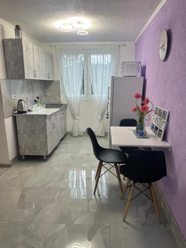 a kitchen with purple walls and a table and chairs at HH Lakes Tuzla - city center, free parking! in Tuzla