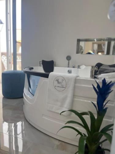 a white bath tub with towels and a plant at La Romantique Rooms and Apartments TROPEA in Parghelia