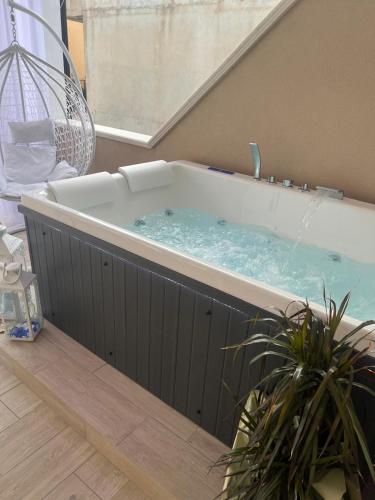 a hot tub in a room with a plant at La Romantique Rooms and Apartments TROPEA in Parghelia