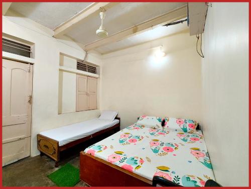 バラナシにあるHOTEL SHANT! GUEST HOUSE VARANASI - 1 Minutes Walking Distance From BABA VISHWANATH TEMPLE And ROOFTOP GANGA VIEW - #Wifi #Fully Air Conditioned & Spacious Rooms -Restaurant Foreigneꭈׁׅ Allowed - Best Budget Guest House In Varanasiのベッドと窓のある小さな寝室