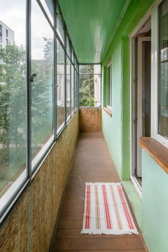 a corridor of a building with windows and a rug at Urban Escape Kaunas - Quiet Apartment 5 km from City Center in Kaunas
