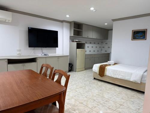 a bedroom with a bed and a table and a kitchen at Blue Garden Resort Pattaya in Jomtien Beach