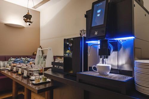 a coffee machine with a cup on a counter at Garner Hotel Aschaffenburg Post by IHG in Aschaffenburg