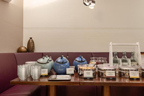 a table with glasses and vases on it at Garner Hotel Aschaffenburg Post by IHG in Aschaffenburg