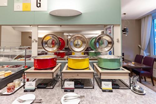 a row of pots and pans on display in a room at Garner Hotel Aschaffenburg Post by IHG in Aschaffenburg