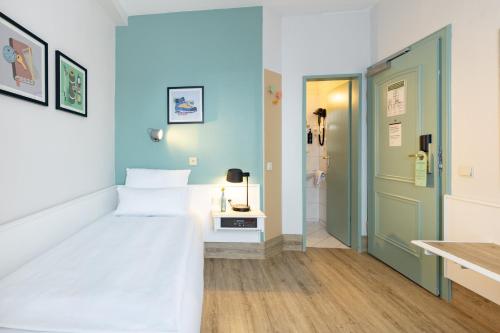 a small room with a bed and a bathroom at Garner Hotel Aschaffenburg Post by IHG in Aschaffenburg