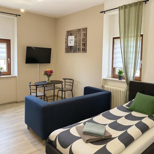 a bedroom with a blue couch and a table at LENASTAY I City Comfort Apartment in Top Location in Kaiserslautern
