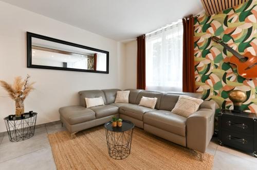 维勒班"La Casa verde" chic et cosy en hypercentre avec climatisation的带沙发和吉他的客厅