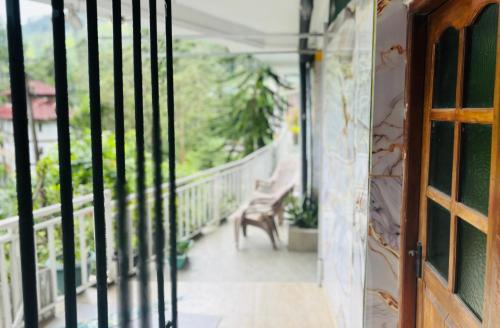 an open door to a balcony with a bench at Grand adamspeak hotel & restaurant in Adams Peak