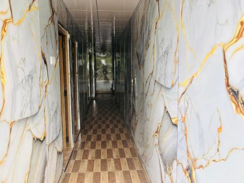 an empty hallway in a building with ailed wall at Grand adamspeak hotel & restaurant in Adams Peak