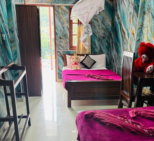 two teddy bears sitting on a bed in a room at Grand adamspeak hotel & restaurant in Adams Peak