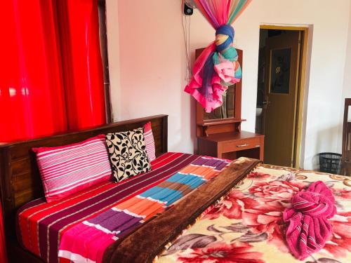 a bedroom with a bed with a colorful comforter at Grand adamspeak hotel & restaurant in Adams Peak