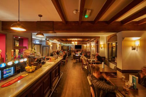 a restaurant with people sitting at a bar at The Barn Hotel & Spa in Grantham