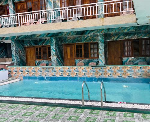 a swimming pool in front of a building at Grand adamspeak hotel & restaurant in Adams Peak