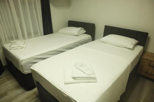two beds with white sheets and a purse on them at lamoza in Narlıdere