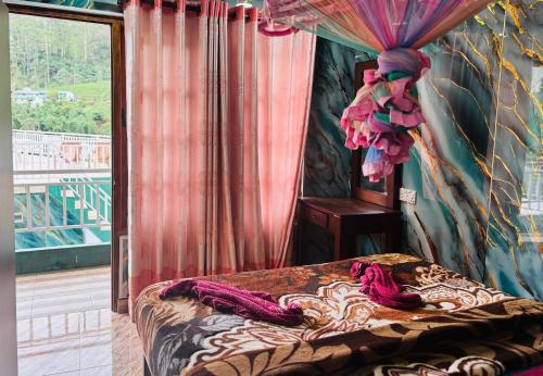 a bedroom with a bed and a window at Grand adamspeak hotel & restaurant in Adams Peak