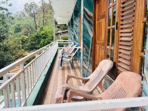 a balcony with chairs on a house at Grand adamspeak hotel & restaurant in Adams Peak