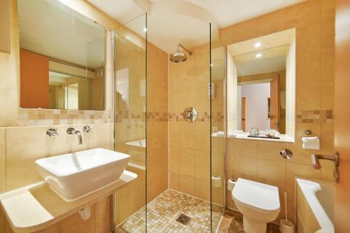 a bathroom with a sink and a toilet and a shower at The Barn Hotel & Spa in Grantham