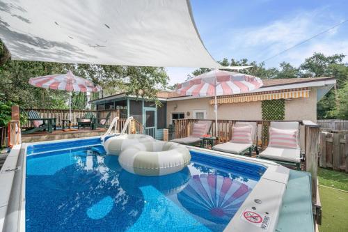 a swimming pool with two umbrellas in a yard at Heated Cocktail Pool, Putt Putt, Bowling, BBQ, Nintendo, Pet Friendly, Ping Pong in St. Augustine