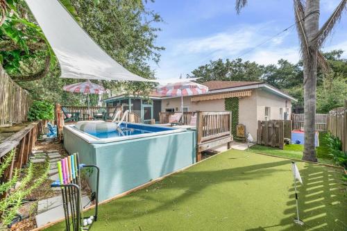 a backyard with a swimming pool and a house at Heated Cocktail Pool, Putt Putt, Bowling, BBQ, Nintendo, Pet Friendly, Ping Pong in St. Augustine