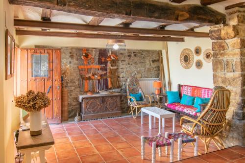 a living room with a couch and chairs and a fireplace at Magnifica casa rural para familias en Navarra in Unzué