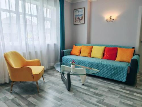 a living room with a blue couch and a chair at Bungalow Step Free Access - Close To The Beach in Port Talbot