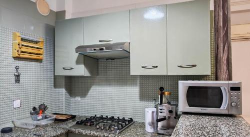 a kitchen with a microwave and a counter top at Appartement a Kantaoui in Port El Kantaoui