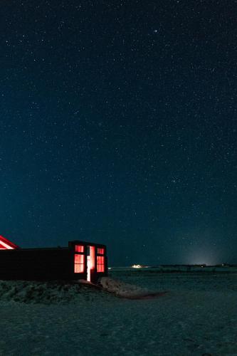 a small building with red lights in the snow at night at Hotel Rangá in Hella