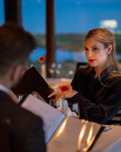 a woman holding a flower in front of a man at Hotel Rangá in Hella