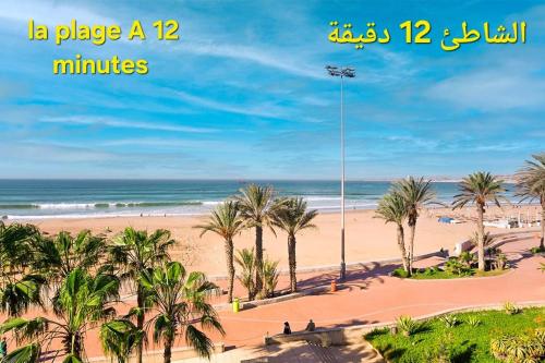 a view of a beach with palm trees and the ocean at appartement bien situé a SALAM in Agadir