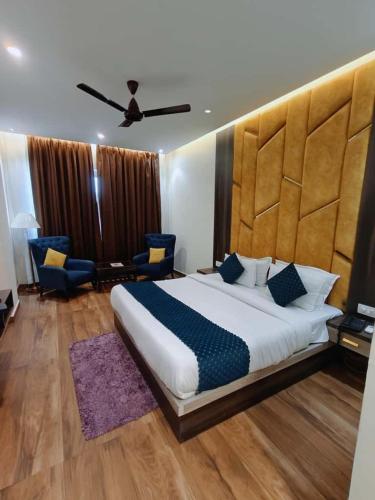 a bedroom with a large bed and a ceiling at Ganges Blossom Luxury Stay in Haridwār
