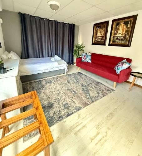 un soggiorno con divano rosso e tappeto rosso di The Lemon Tree Self Catering Cottage a Bloemfontein