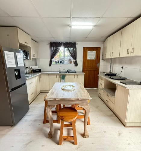 una cucina con tavolo in legno e sgabello in legno di The Lemon Tree Self Catering Cottage a Bloemfontein