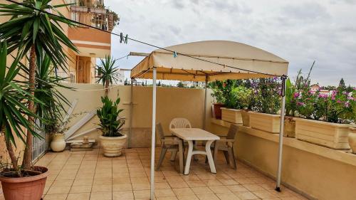 a table and chairs under an umbrella on a balcony at Appartement de Rêve in Port El Kantaoui