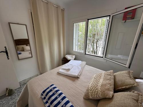 a bedroom with a bed with two pillows and a window at Preciosa casa con piscina desbordante y vistas al mar in Roses