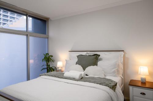 a bedroom with a large white bed with two pillows at Brisbane Central CBD convivence! in Brisbane