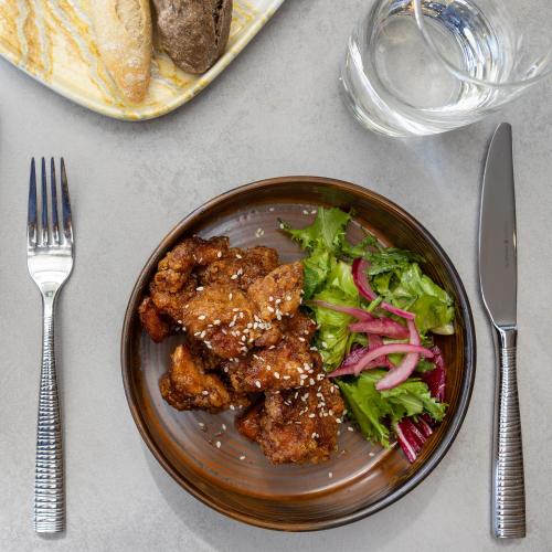 a plate of food with meat and salad on a table at Holiday Inn Manchester-Mediacityuk by IHG in Manchester