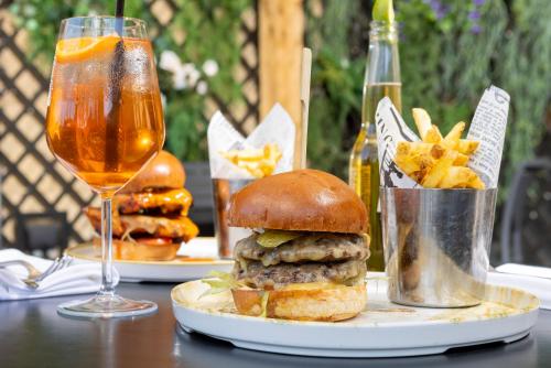 a hamburger and fries on a table with a glass of beer at Holiday Inn Manchester-Mediacityuk by IHG in Manchester