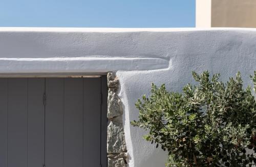 a window of a building with a plant next to it at Seven Suites in Glinado Naxos