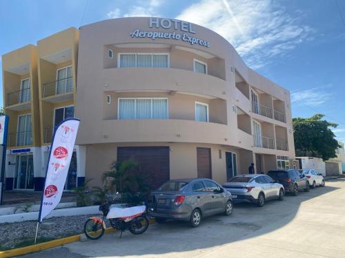 a hotel with cars parked in front of it at Aeropuerto express in Bahías de Huatulco