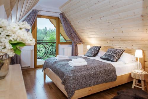 a bedroom with a bed with two towels on it at Dom Wypoczynkowy Koliba in Białka Tatrzanska
