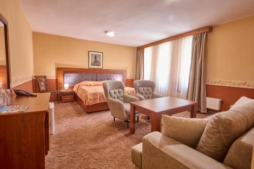 a hotel room with a bed and a living room at Хотел "Калина" in Borovets