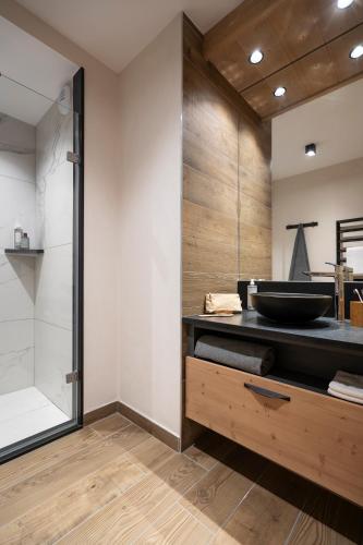 a bathroom with a sink and a shower at MGM Hôtels & Résidences - Résidence Le Hameau de l'Ours in Manigod