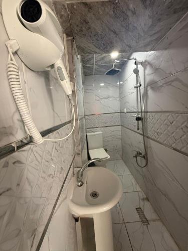 a white bathroom with a shower and a toilet at Kennedy Hotel Kumkapı in Istanbul