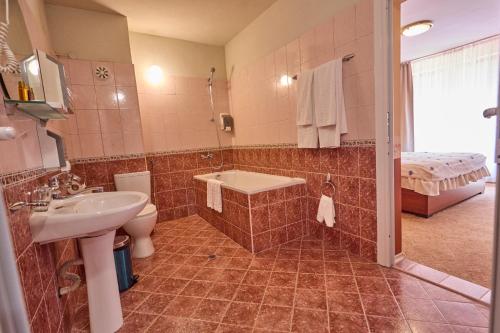 a bathroom with a sink and a toilet and a tub at Хотел "Калина" in Borovets