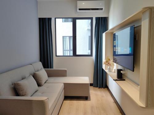 a living room with a couch and a flat screen tv at Vetro11 Beside QEH1 by JUNE Homestay in Kota Kinabalu