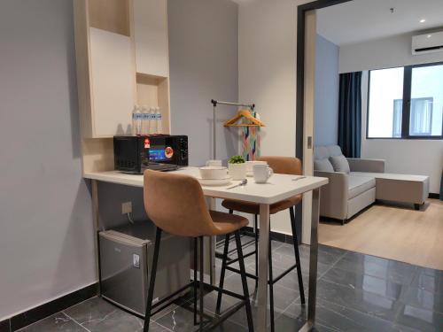 a kitchen and living room with a table and chairs at Vetro11 Beside QEH1 by JUNE Homestay in Kota Kinabalu