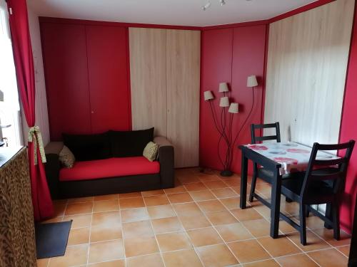 un salon avec un canapé rouge et une table dans l'établissement Gîte du Pagoulin - Coquelicots, à Hyères