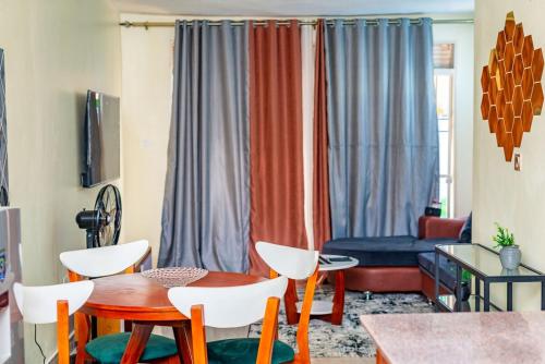 a living room with a table and chairs at Bright & Airy 2BR Haven in Kampala